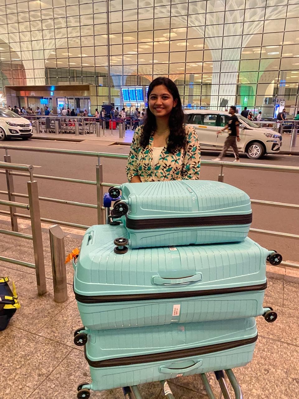 Heena at the airport with three matching suitcases